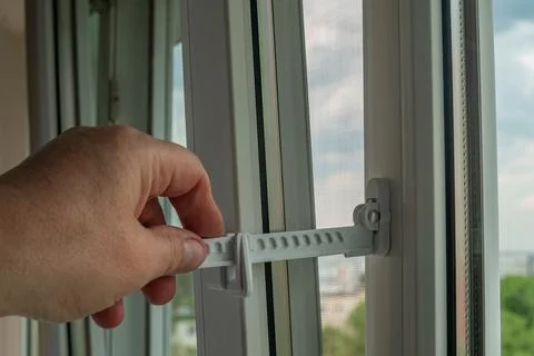 Master installed fixing limiter for opening a plastic window and checks its.. Stock Photos
