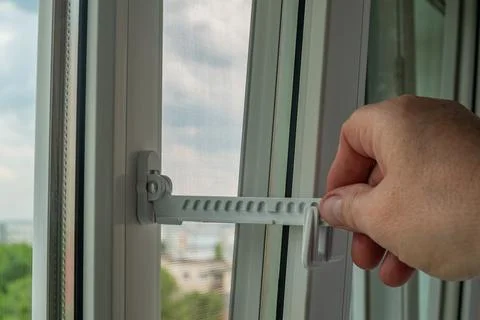 Master installed fixing limiter for opening a plastic window and checks its.. Stock Photos