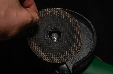 Master installs a disc on an angle grinder Stock Photos