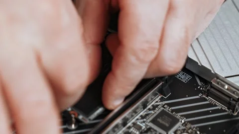 Master installs SSD m2 sata on motherboard. motherboard during custom PC Stock Footage 301717052
