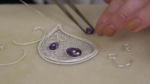Master jeweler with professional tweezers putting the gem on the necklace Stock Footage