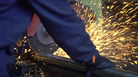 Master of the lathe is cutting a metal pipe with a bolt cutter. Metalworker on Stock Footage 237802897