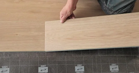 The master is laying the laminate. The man is doing the repair of the floor Stock Footage 240636213