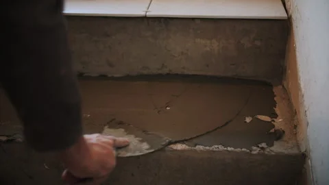 The master lays ceramic tiles on the steps Stock Footage 292532572