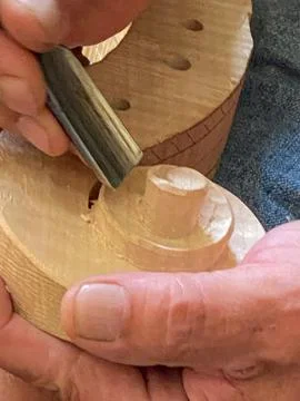 Master luthier violin maker working on violin scroll in his workshop Stockfoto's