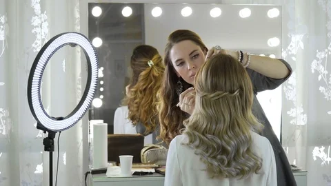 The master in a make-up prepares model for display in beauty shop. The makeup Stock Footage 74930264