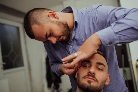 Master makes beards correction in barbershop salon. Close up photo. Stock Photos