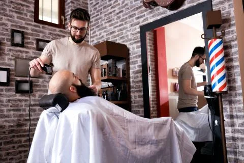 Master makes beards correction with trimmer Stock Photos