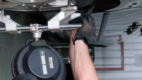The master makes the camber of the wheels of the car. Balancing the chassis of Stock Footage 250026767