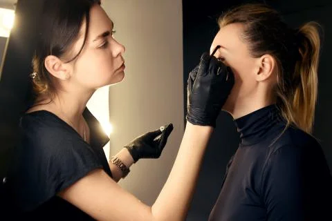 Master makes eyebrows. Eyebrow lamination. The girl makes eyebrows in the salon. Stock Photos