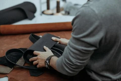 The master makes a leather bag. A close up, a product from skin in hands. Stock Photos