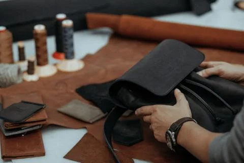 The master makes a leather bag. A close up, a product from skin in hands. Stock-Fotos