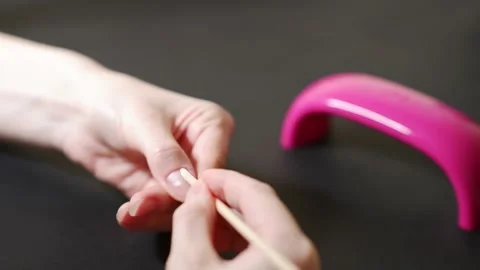 The master makes a manicure to the client. Pushing back cuticles on nails. Stock Footage 169303836