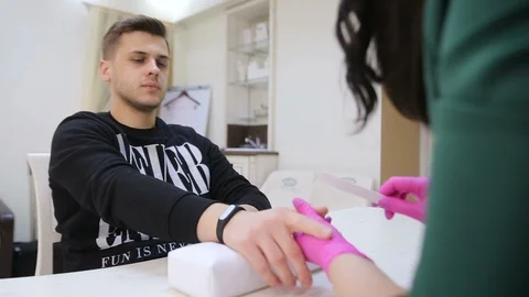 Master makes manicure to the man Stockbeeldmateriaal 106405757