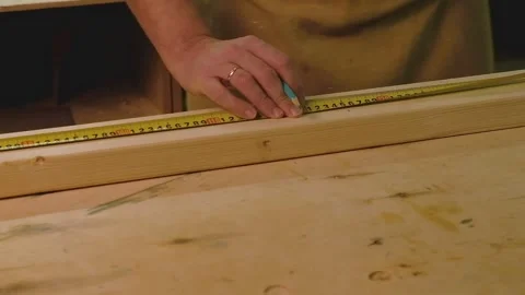 The master makes a marking with a tape measure on a blackboard lying on the d Video stock 182229500