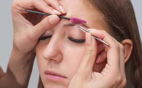 Master makeup corrects eyebrows Stock Photos