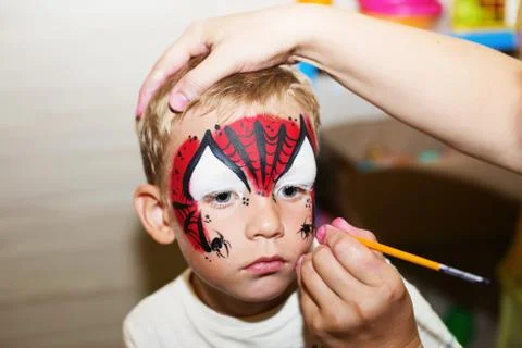 Master making aqua makeup on boys face Stock Photos
