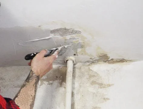 Master man applying putty plaster to the ceiling close-up Stock Photos