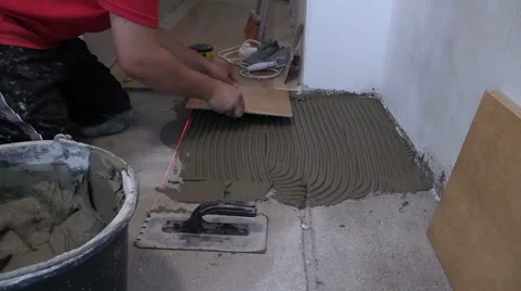 Master man lay ceramic floor tiles in kitchen Stock Footage 42806294