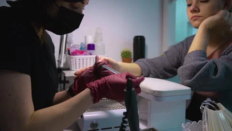 Master of manicure nail file makes shape nails of client who leaned on her hand Stock Footage 146488935