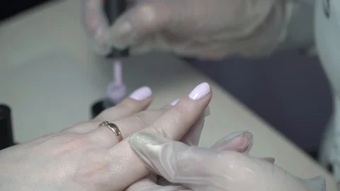 Master in manicure nail polish in the hands of the beauty salon Stock Footage 87465642