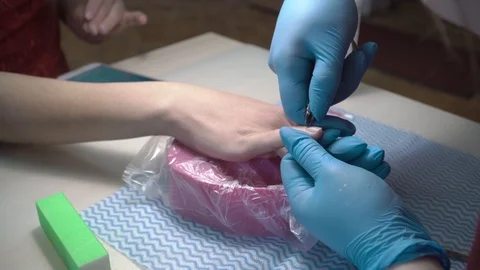 Master of manicure removes cuticles on nails in beauty salon Stock Footage 87464574