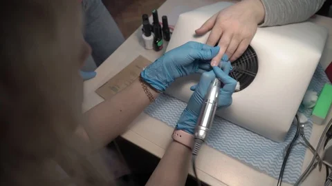 Master of manicure removes cuticles on nails in beauty salon Stock Footage 87469749