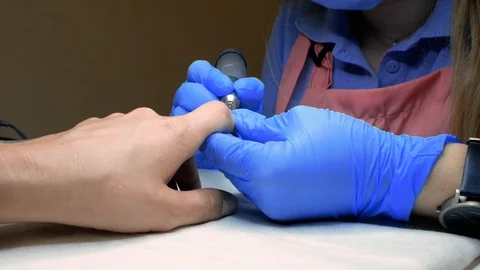 Master of manicure removes cuticles on nails. manicurist makes hardware manicure Stock Footage 114314506