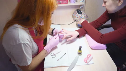 Master of manicure at work. Services in the beauty salon. Two young attractive Stock Footage 87120692