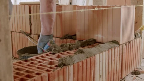 A master mason builds a red brick wall. The master on the construction site Stock Footage 245846480