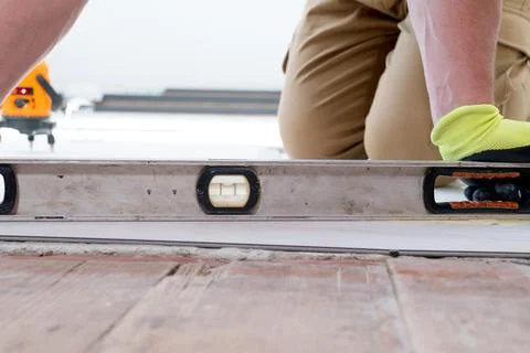 The master measures the level of the floor surface. 스톡 사진