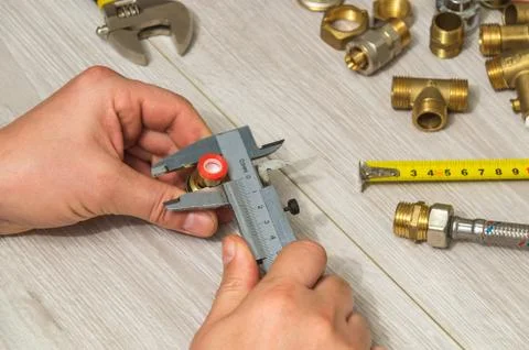 The master measures the size of fitting using caliper before connecting Stock Photos