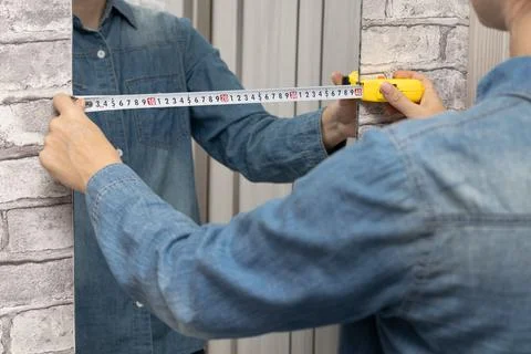 The master measures the width of the mirror. Stock Photos