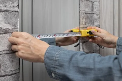 The master measures the width of the mirror. Stock Photos