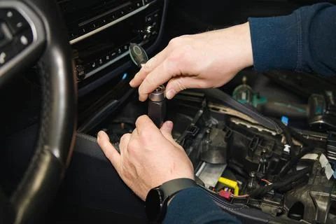 A master mechanic disassembles a car interior using a ratchet screwdriver Stock Photos