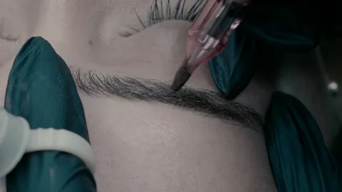 Master of microblading at work makes a pigment on the eyebrow. Видео 223156193