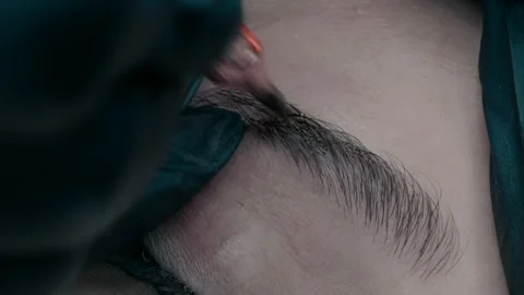 Master of microblading at work makes a pigment on the eyebrow. close up video Видео 223157712