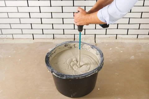 The master mixes the plaster in a bucket. Flat house renovation, master mixed Foto stock