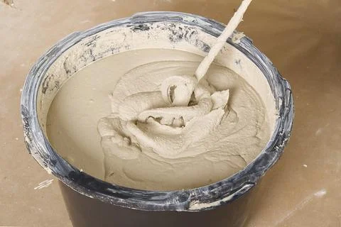The master mixes the plaster in a bucket. Flat house renovation, master mixed Stock Photos
