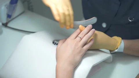 The master of the nail service sharpens the client's nails with a nail file Vidéo 165222788