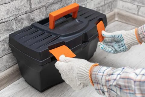 The master opens the box with the tool. Stock Photos