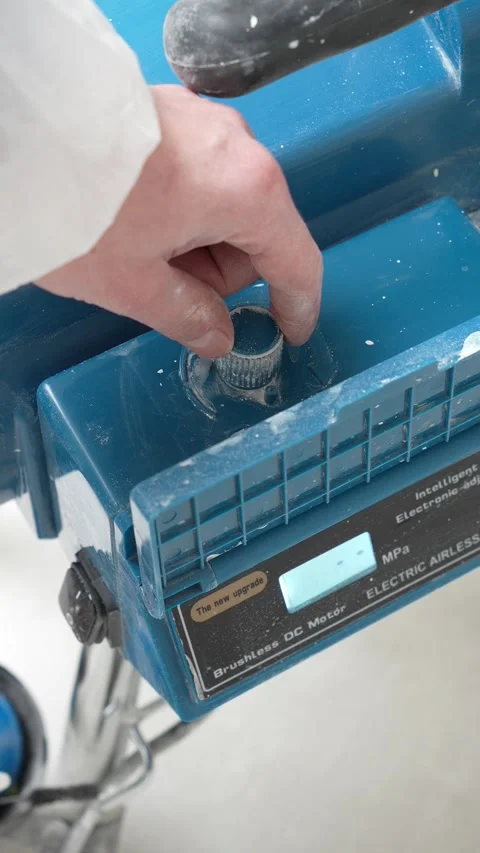 Master painter adjusts the power of the airless painting and priming machine Stock Footage 317395259
