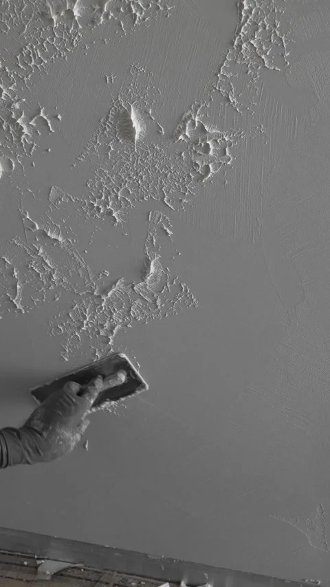 Master painter builder creates a pattern on decorative plaster with a spatula Stock Footage 317409566