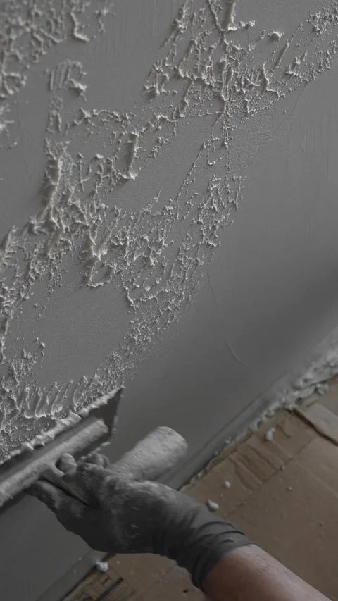 Master painter builder creates a pattern on decorative plaster with a spatula Video stock 317409568