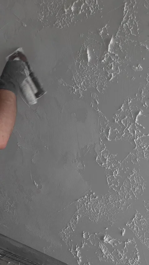 Master painter builder creates a pattern on decorative plaster with a spatula Video stock 317409573