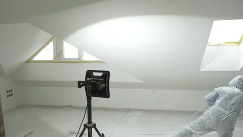 A master painter  paints and primes a wall with an airless paint sprayer Stock Footage 317394932