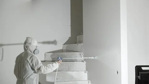 A master painter  paints and primes a wall with an airless paint sprayer Video stock 317395033