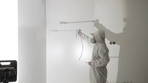A master painter  paints and primes a wall with an airless paint sprayer Stock Footage 317395044