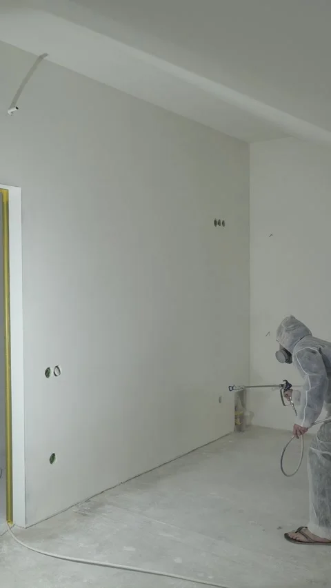 A master painter  paints and primes a wall with an airless paint sprayer Video stock 317395416