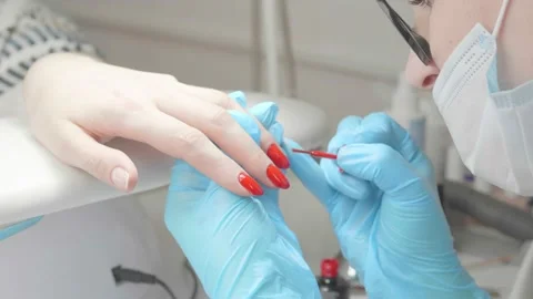 The master paints the client's nails red Stock Footage 195733958